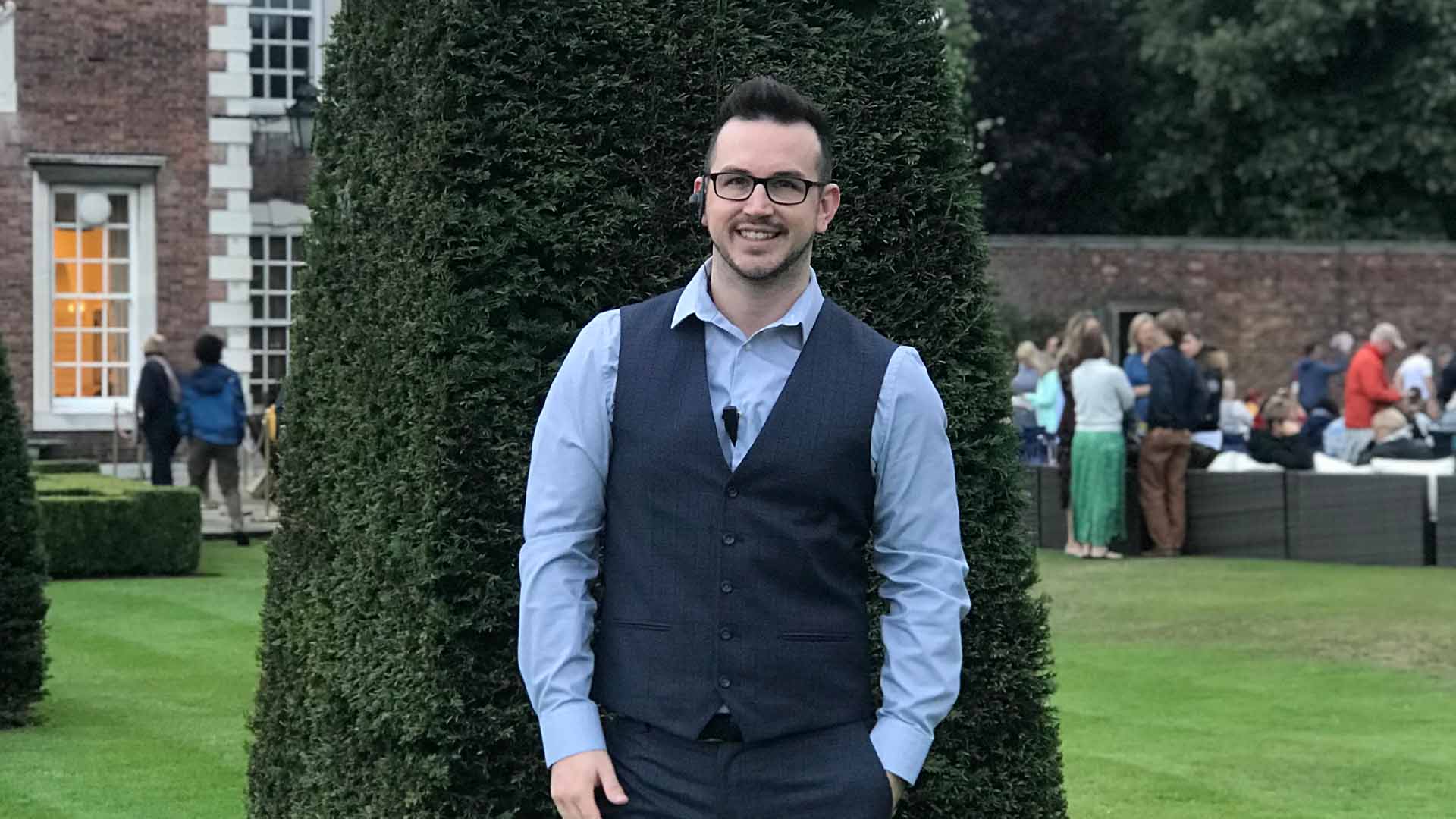 A mad with a shirt and waist coat on standing in the gardens of Knowsley Hall