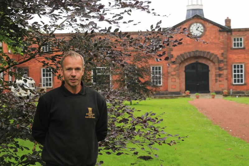 A gardener standing by a building in the Knowsley Estate