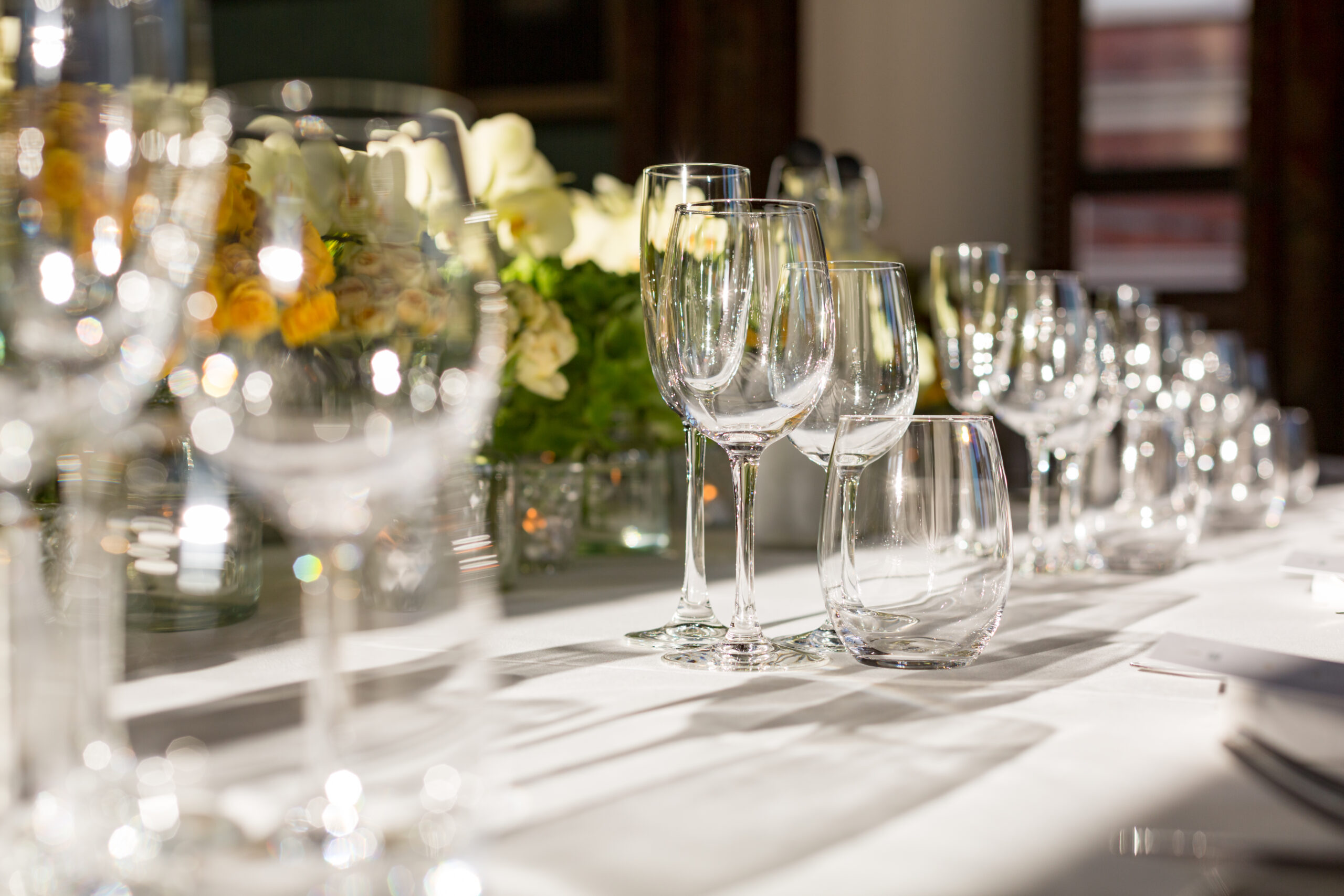 Wine glasses on a dining table with fresh flowers for a corporate dining event