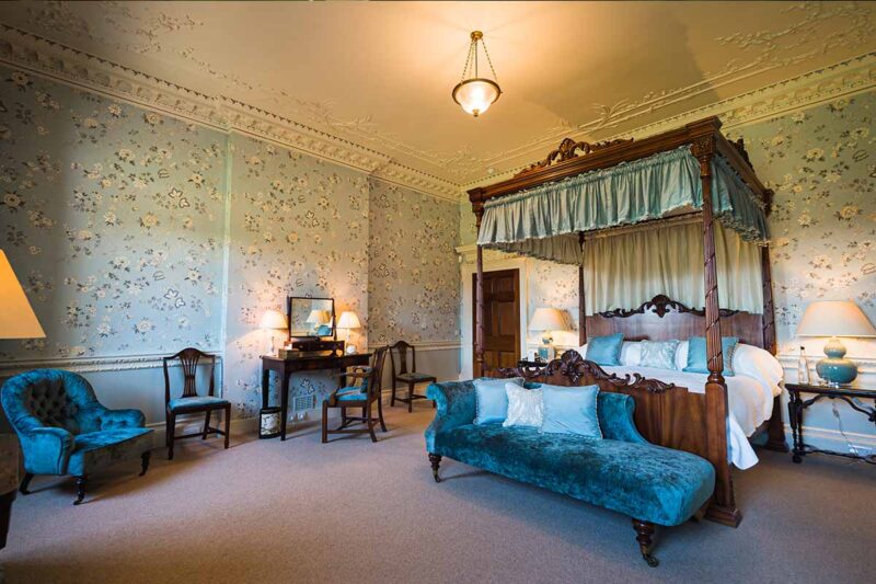 Large deluxe bedroom with four poster Mahogany bed, dressing table and chair with bed side tables and lamps