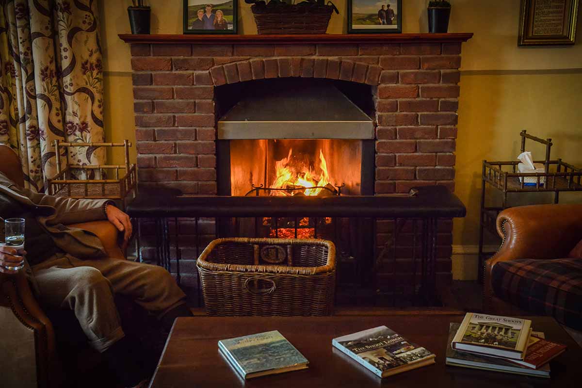 Roaring open fire with people sitting next to it after a day of pheasant shoot