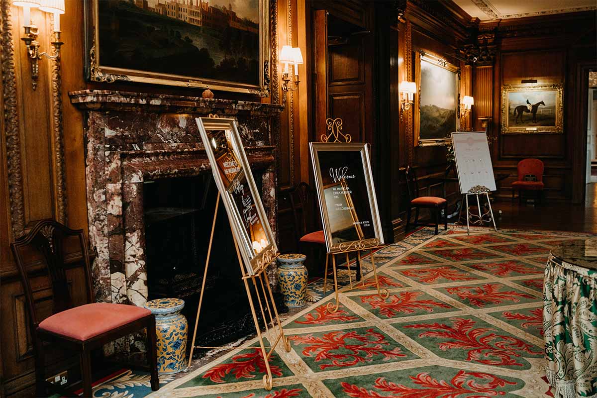 Historic house in Entrance Hall with oak panelling and wedding table plan signs ready for a wedding day