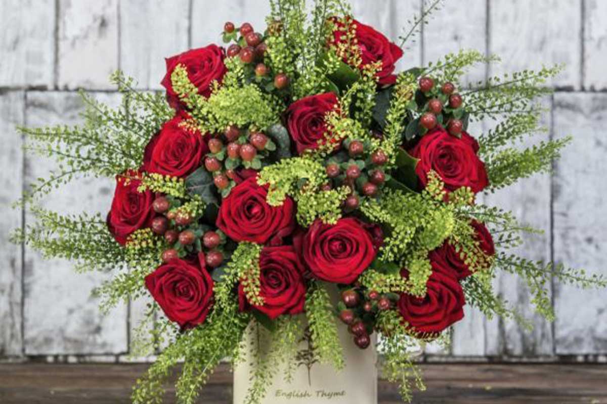 A beautiful floral display of fresh red roses, red berries.