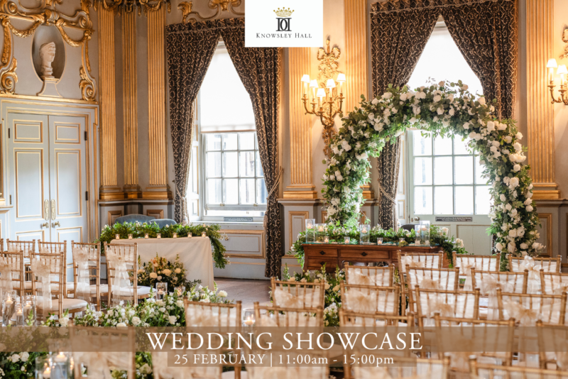 A grand room with gold detail dressed with flowers and elegant chairs for a wedding ceremony